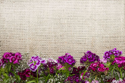 Bright purple and violet flowers on a burlap background, top horizontal boards, copyspace