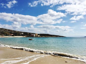 Scenic view of beach against cloudy sky