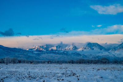 Scenic view of snowcapped mountains against blue sky
