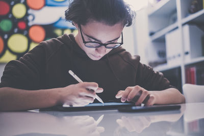 Teenager drawing with tablet and virtual pen. student doing homework with new technology devices. 