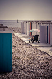 Deck chairs on beach against clear sky