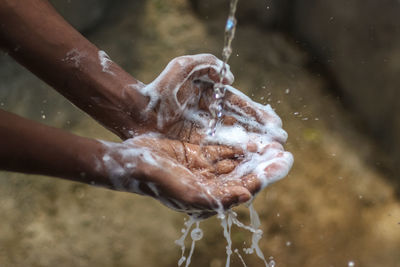 Close-up of human hand feeding in water