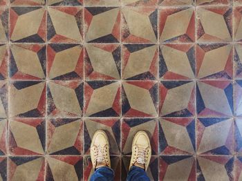 Low section of person standing on tiled floor