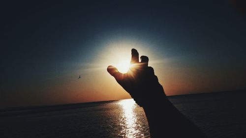 Cropped image of man looking at sunset