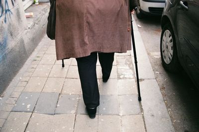 Low section of woman standing on street in city