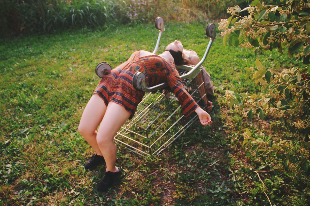 Female friends lying on shopping cart