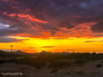 Scenic view of landscape against orange sky