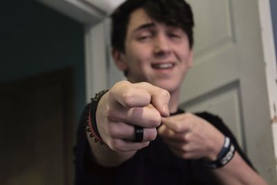 Portrait of teenage boy gesturing while standing at home