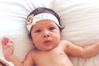 High angle portrait of shirtless baby on bed at home