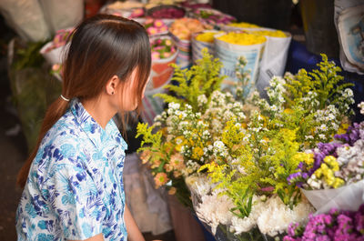 Midsection of woman standing by potted plants at market