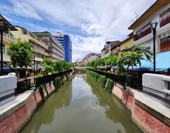 Canal amidst buildings against sky
