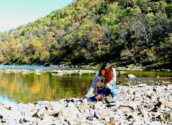 Man sitting on rock by lake