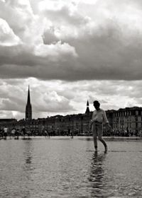 River in city against cloudy sky