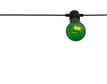 Low angle view of illuminated light bulb against wall