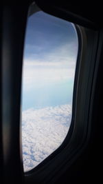 Aerial view of sea seen through airplane window