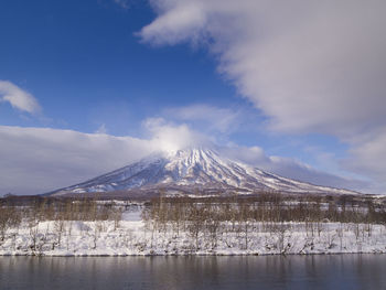 Scenic view of snowcapped mountains by lake against sky