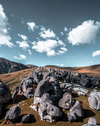 Stack of rocks on landscape against sky