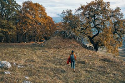 Rear view of woman walking on street during autumn