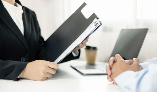 Midsection of businessman using laptop