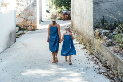 Rear view of women walking on road