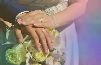 Midsection of bride holding bouquet