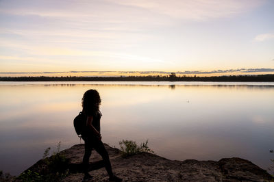Traveler woman walking by the lake during sunset.