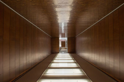 Empty corridor in illuminated building