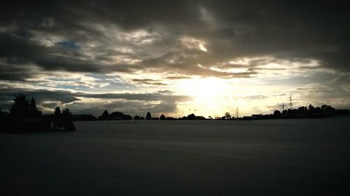 Silhouette of trees against cloudy sky