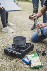 Cropped image of woman preparing coffee on camping stove