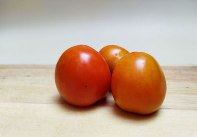 Close-up of oranges on table against white background