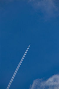 Low angle view of vapor trail against blue sky