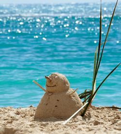 Snowman made of sand at beach