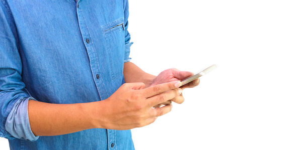 Midsection of woman holding smart phone against white background