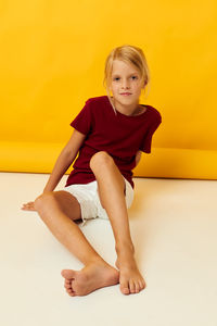 Portrait of young woman sitting on hardwood floor at home