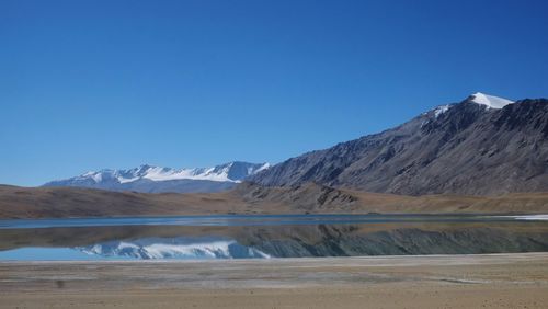 Scenic view of snowcapped mountains against blue sky