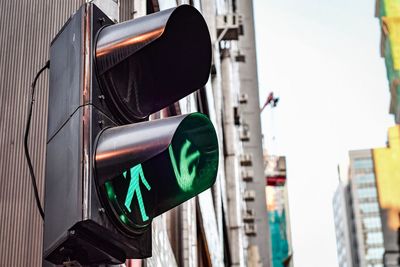 Low angle view of road signal against sky