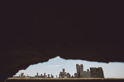 Arundel castle against sky seen through hole in wall