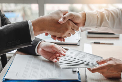 Midsection of man holding hands on table