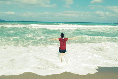 Full length of happy woman standing on beach