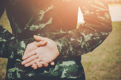 Midsection of female soldier standing on field