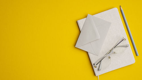 High angle view of paper against yellow background