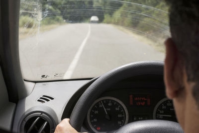 Man seen through car windshield