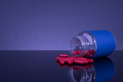 Close-up of red light on table against blue background
