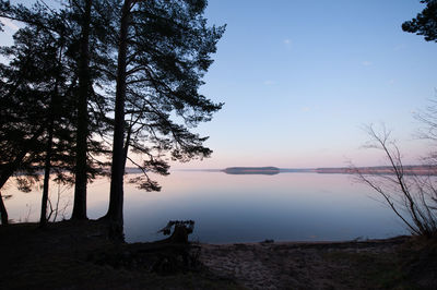 Silhouette trees by lake against sky during sunset