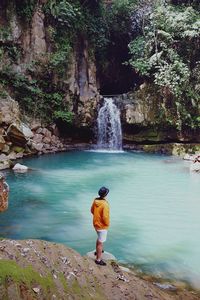 Full length of man standing by river in forest