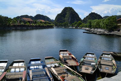 Boats moored in lake against mountains