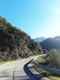 Road by mountains against clear blue sky