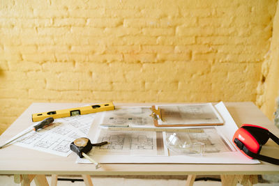 Blueprints, ear defenders, protection glasses and tools on architect workspace at construction site