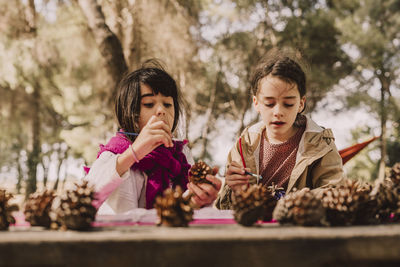 Low angle view of women looking at tree