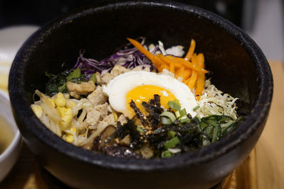 Close up korean bibimbap served in a heated stone bowl